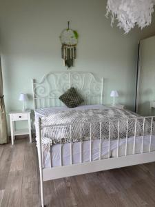 a white bed in a room with a white wall at Maison chez Louis in Asuel