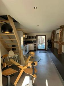 a kitchen with a glass table and wooden chairs at La grange de Tom in Marche-en-Famenne