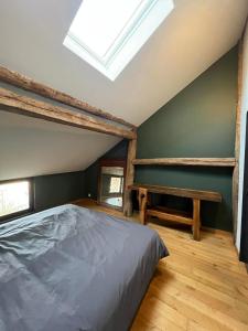 a bedroom with a bed and a skylight at La grange de Tom in Marche-en-Famenne