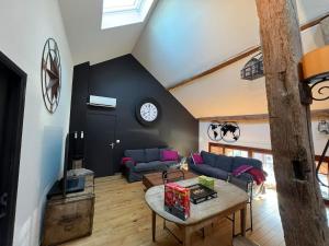 a living room with a couch and a table at La grange de Tom in Marche-en-Famenne