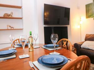 a dining room table with wine glasses and a television at Natures Retreat in Matlock