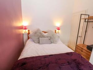 a bedroom with a bed with pillows and two lamps at Natures Retreat in Matlock