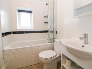 a white bathroom with a toilet and a sink at Natures Retreat in Matlock +18 photos