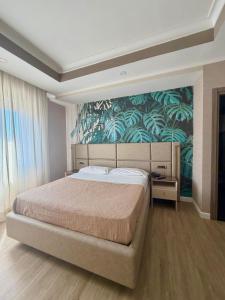 a bedroom with a large bed with a tropical wallpaper at Hotel Daytona Palace in Casoria +61 photos