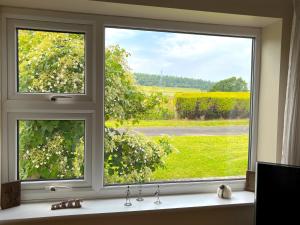 a window with a view of a green field at The Old Tearooms in Rural Northumberland in Edlingham
