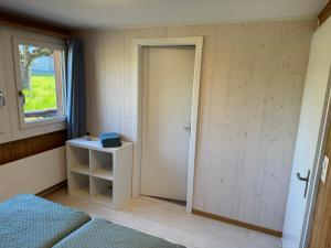 a room with a door and a bed and a window at See und Berge Cozy in Faulensee
