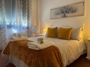 a bedroom with a bed with towels on it at Apartamento Estela in Combarro