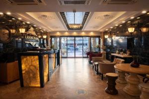 a restaurant with a bar and tables and chairs at Lion Park Suites & Residence Hotel in Aydın