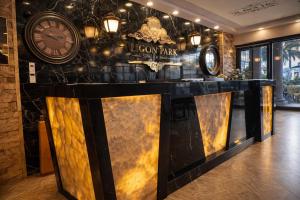 a bar in a lobby with a clock on the wall at Lion Park Suites & Residence Hotel in Aydın