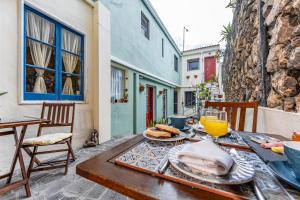 a wooden table with food and drinks on a patio at A-Típica GuestHouse in Ponta Delgada