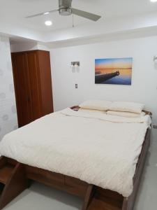 a bed in a bedroom with a white wall at Iluka 2- By the Bay in Puerto Galera