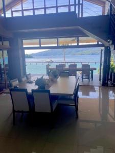 a dining room with a table and chairs with a view of the ocean at Iluka 2- By the Bay in Puerto Galera +18 photos