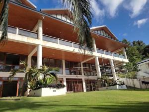 a building with a palm tree in front of it at Iluka 2- By the Bay in Puerto Galera