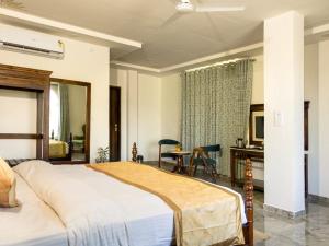 a bedroom with a large bed and a table and chairs at Jaisamand Garh Resort in Udaipur