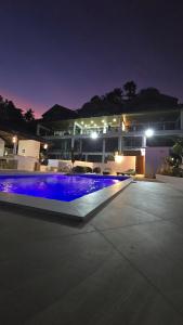 a swimming pool with blue lights in front of a building at Iluka 2- By the Bay in Puerto Galera