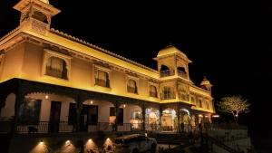 a large building with a clock tower at night at Jaisamand Garh Resort in Udaipur