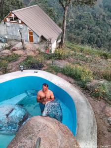 a man in a swimming pool with a turtle in it at Paradise Point Nature Cabana Kandy in Kande