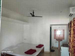 a bedroom with a bed and a ceiling fan at Shraddha Cottage in Nagaon