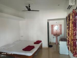 a bedroom with a bed and a ceiling fan at Shraddha Cottage in Nagaon