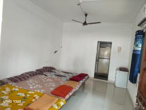 a bed in a room with a ceiling fan at Shraddha Cottage in Nagaon