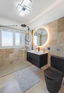 a bathroom with a sink and a toilet and a mirror at Panorama Majestic in Saint-Raphaël +21 photos