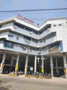 a large white building with motorcycles parked in front of it at Hotel Royal Manor in Rajkot