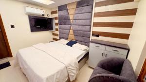a small bedroom with a bed and a chair at Pragati Guest House in Gorakhpur +35 photos