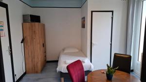 a small room with a table and a bed at Chambre quadruple in Lully