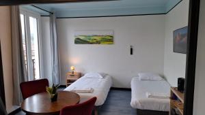 a hotel room with two beds and a table at Chambre quadruple in Lully
