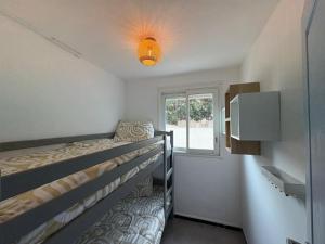 a bedroom with two bunk beds and a window at Strandhuisje aan de Middellandse Zee in Palavas-les-Flots