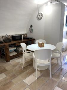 a dining room with a white table and white chairs at i GERMÅNI REALI in Scanno