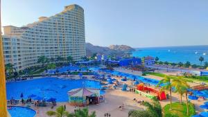 a resort with a large swimming pool next to the ocean at بورتو السخنه الاهرامات in Banī Ghālib