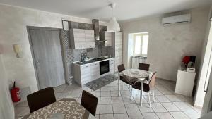 a kitchen with a table and a table and chairs at Agherè in Agira