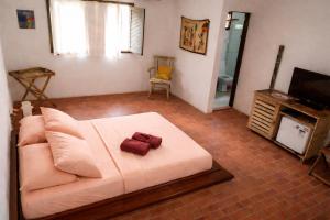 a living room with a white couch and a television at Exclusive Guest House - Suites Charmosas na Vila in Porto De Galinhas