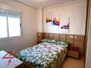 a bedroom with a bed and paintings on the wall at Magic World Vistamar lll in El Borseral +14 photos