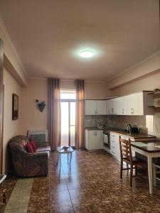 a kitchen and living room with a couch and a table at Jozi Kaiser Apartment 4 in Durrës