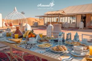 a table with food and drinks on top of it at Azawad Desert Luxury Camp in Merzouga