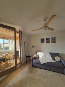 a living room with a couch and a ceiling fan at Cozy studio proche plages et gare in Sanary-sur-Mer