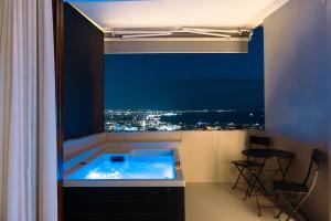 a room with a tub with a view of a city at Acropoleos Suites in Thessaloniki
