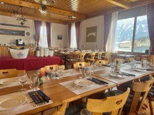 a dining room with a large wooden table and chairs at Hotel La Tour d'Aï in Leysin