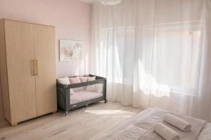 a bedroom with a crib next to a window at Iris Home in Székesfehérvár