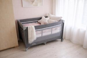 a gray crib with pillows on it in a room at Iris Home in Székesfehérvár