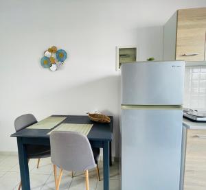 a kitchen with a refrigerator and a table with chairs at Dodekanisos Studios in Faliraki +7 photos