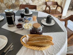 a table with a basket of bread on a table at Chambre quadruple vue mer Le Bouye in Mar Lodj