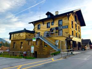 a large yellow building on the side of a street at Hotel La Tour d'Aï in Leysin