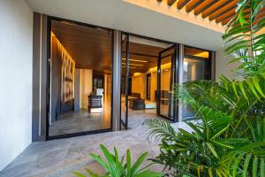 an external view of a house with large glass doors at S Resort El Nido Managed by H Hospitality Group - Newly Renovated in El Nido