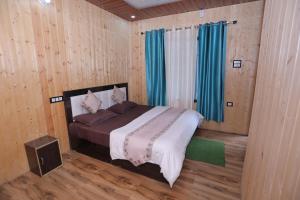a bedroom with a bed in a room with wooden walls at Brahamkamal Resort in Gupta Kāshi