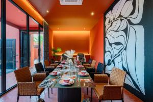 a dining room with a long table and chairs at Afro Pool Villa Bangsean 01 in Ban Puk (2)