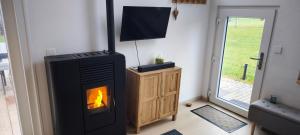 a fireplace in a living room with a fire at En aparté in Vielsalm