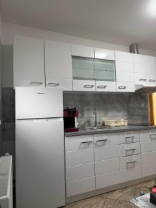 a kitchen with white cabinets and a white refrigerator at APARTMAN i SOBA HADELA in Sveti Martin na Muri